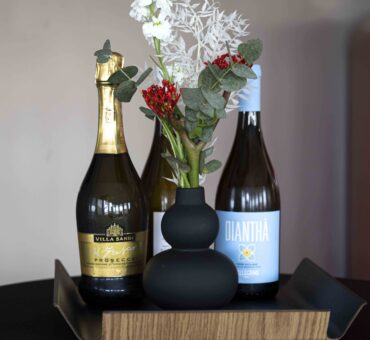 Zwei Flaschen Prosecco und Weißwein mit Blumenschmuck auf einem Tisch – stilvolles Getränkesetup im MeetingRAUM Ingolstadt für besondere Anlässe.